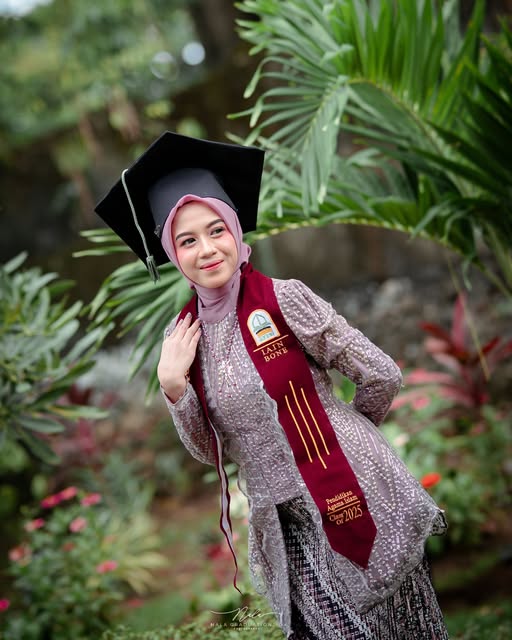 Wisudawati IAIN Bone dengan toga di antara dedaunan